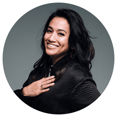 Dr. Neeta, On Your Terms Podcast Listener, poised portrait captures her in a graceful stance, elegantly posing for the camera with one hand gently resting on her chest. Dressed in a refined black sweater, her poised demeanor and confident gaze reflect professionalism and grace.
